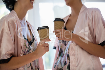 Smiling women interacting while having coffee