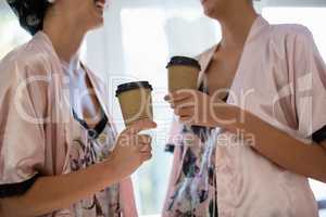 Smiling women interacting while having coffee