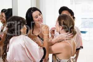 Bridesmaid assisting bride in getting ready