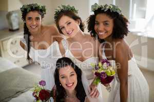 Portrait of smiling bride and bridesmaid in living room