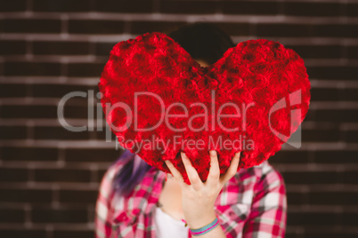 Woman hiding face from heart shape