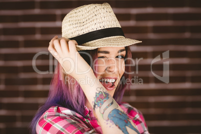 Smiling woman posing against brick wall