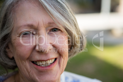 portrait of cheerful senior woman standing in park