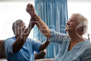 Nurse helping senior woman in flexing muscles