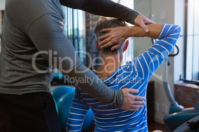 Physiotherapist assisting senior woman in exercise