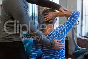 Physiotherapist assisting senior woman in exercise