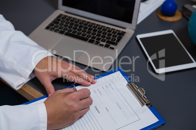 Physiotherapist writing prescription on clipboard