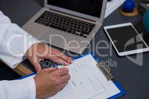 Physiotherapist writing prescription on clipboard