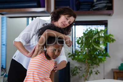 Physiotherapist giving hand massage to a girl