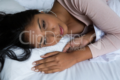 Thoughtful woman relaxing on bed