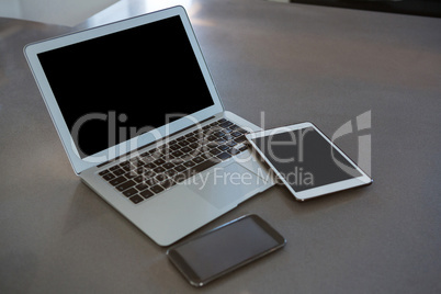 Laptop with tablet and phone on kitchen counter