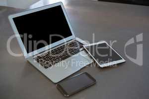Laptop with tablet and phone on kitchen counter