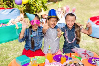 Portrait of children gesturing while sitting at table