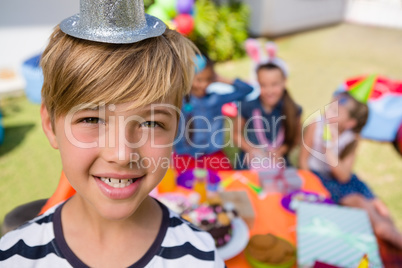 Close up portrait of happy boy with friends in background