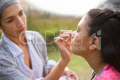 Close up of woman applying face paint