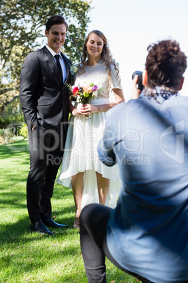 Photographer taking photo of newly married couple