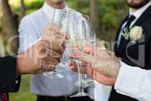 Groom and guests toasting glasses of champagne