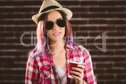 Beautiful woman in sunglasses holding coffee cup