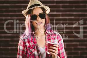 Beautiful woman in sunglasses holding coffee cup