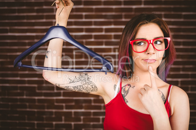 Confused woman holding hanger
