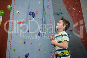 Boy preparing for rope climbing in fitness studio