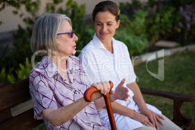 Senior woman talking to doctor while sitting in park