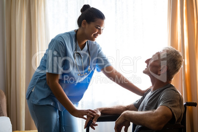 Female doctor interacting with senior man in nursing home