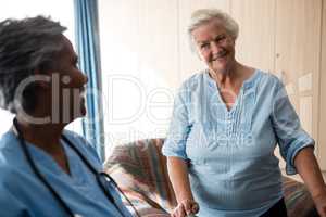 Smiling nurse and senior woman looking at each other