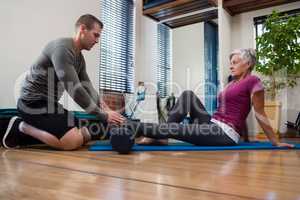 Physiotherapist giving physical therapy of leg to senior patient