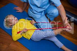 Female physiotherapist assisting a girl patient while exercising