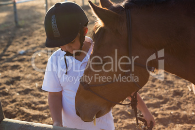 Boy feeding the horse in the ranch