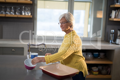 Senior women picking up a bowl