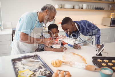 Multi-generation pouring milk in a jar while preparing cookies