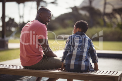 Father talking to son near pool side