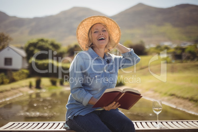 Senior woman reading a book on park bench