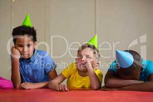 Bored children wearing party hat at table
