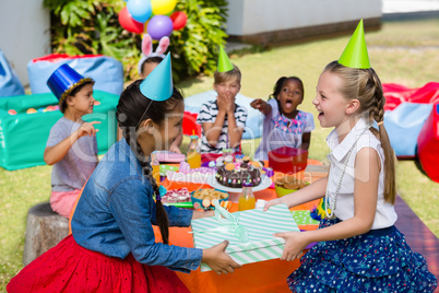 Friend giving gift to girl