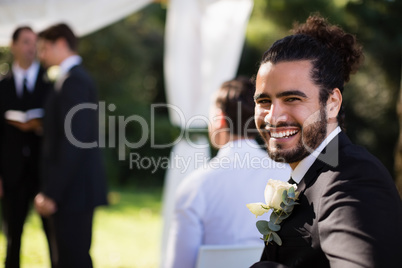 Portrait of handsome groomsman smiling in park