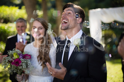 Couple playing with bubbles in park