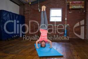 Happy teenage girl performing headstand