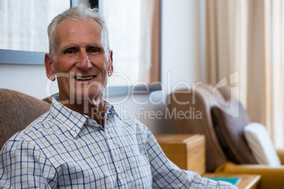 Portrait of senior man relaxing on armchair in nursing home
