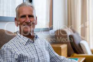 Portrait of senior man relaxing on armchair in nursing home