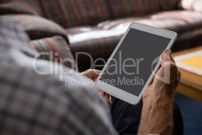 Hands of senior man using tablet computer while sitting in nursing home