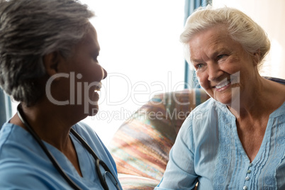 Nurse talking to senior patient in nursing home