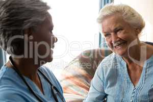Nurse talking to senior patient in nursing home