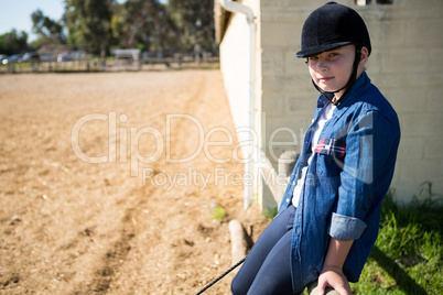 Girl sitting on wooden fence in the ranch