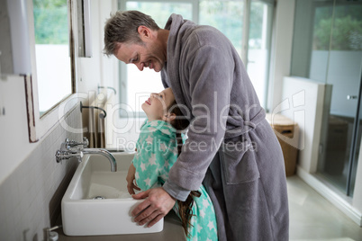 Father and daughter standing in bathroom