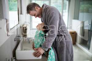 Father and daughter standing in bathroom