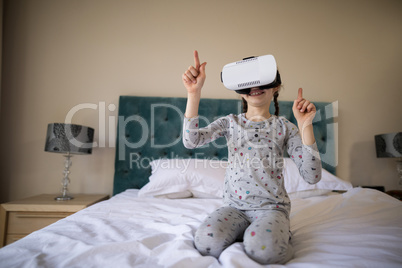 Girl using virtual reality headset on bed