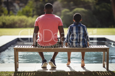 Father and son sitting together on bench